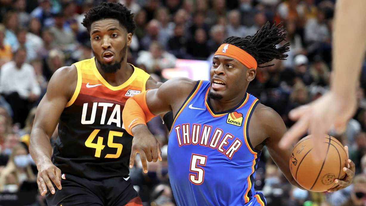 Utah Jazz guard Donovan Mitchell (45) tries to stay with Oklahoma City Thunder forward Luguentz Dort (5) as the Utah Jazz and the Oklahoma City Thunder open the 2021-22 season at Vivint Arena in Salt Lake City on Wednesday, Oct. 20, 2021.