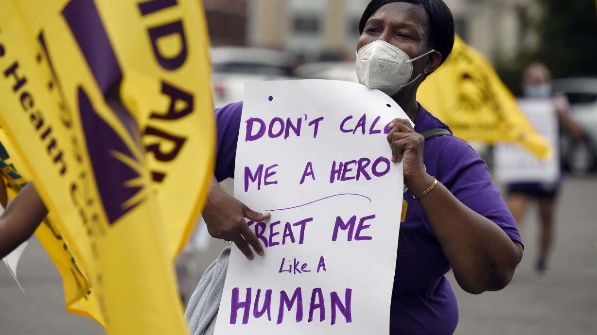 Clarissa Johnson of Hartford marches with long-term care members of the New England Health Care Employees Union, during a rally to demand new laws to protect long-term caregivers and consumers, July 23, 2020, at the State Capitol in Hartford, Conn. Connecticut essential state employees, who worked long hours during the COVID-19 pandemic, are still waiting for "hero pay" from $22.5 million in federal pandemic funds set aside in the state budget.