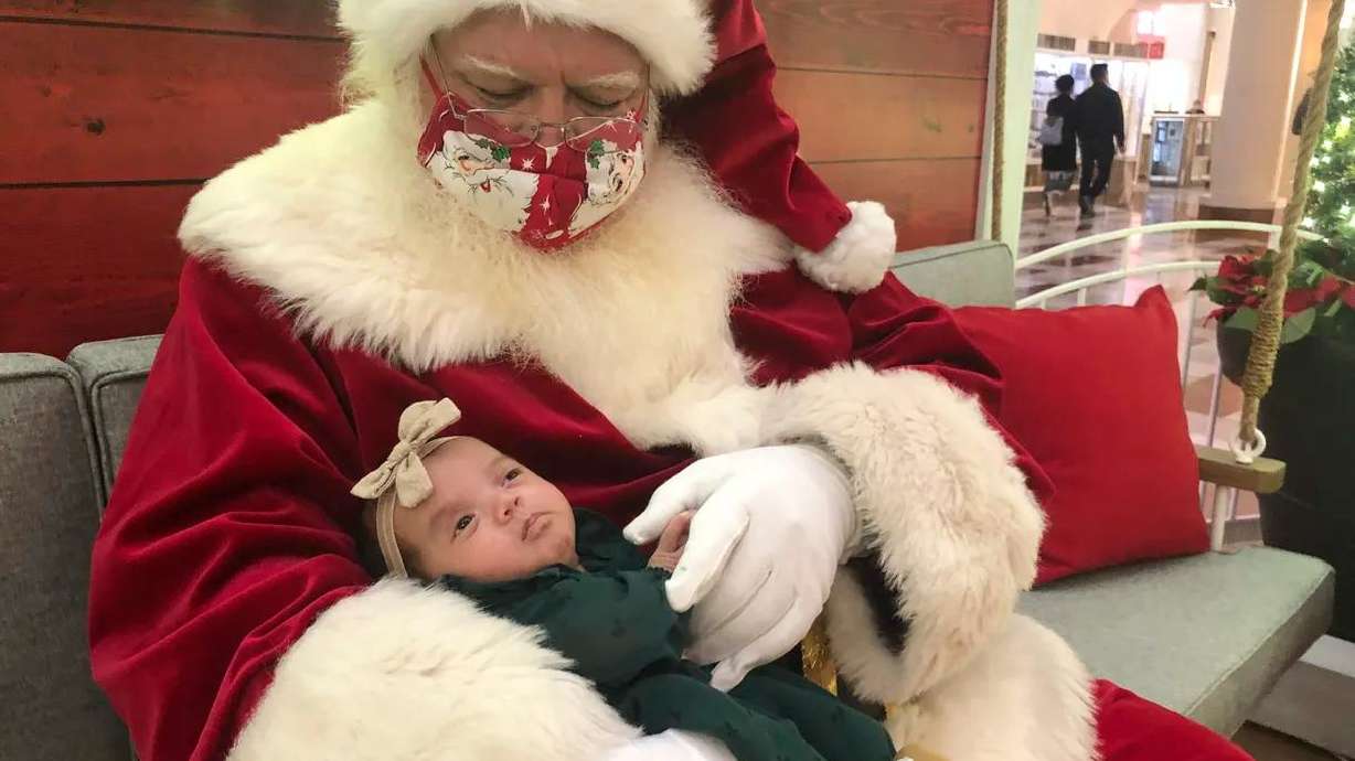 A Santa holds a baby at Stonestown Galleria in San Francisco, on Nov. 22.