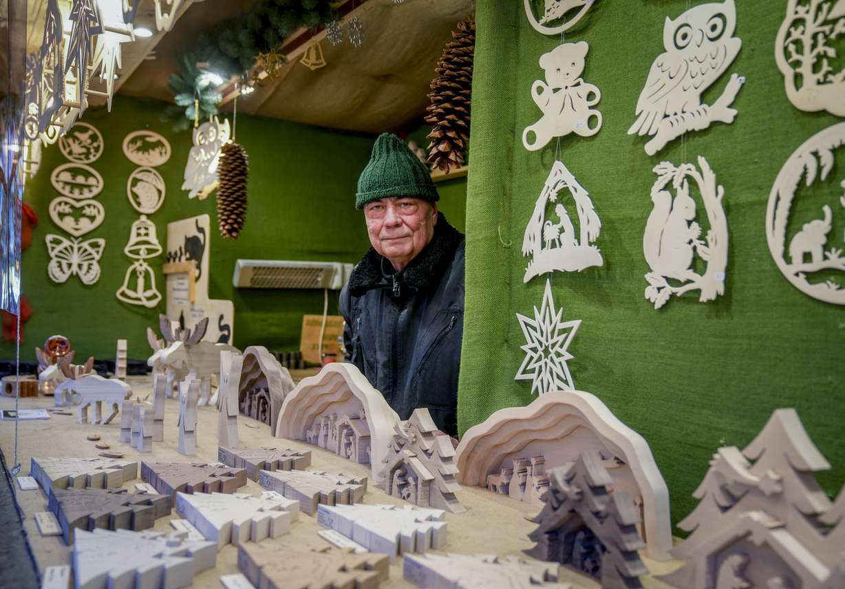Vender Nils Knauerbstnads stands in his booth at the Christmas market in central Frankfurt, Germany, Tuesday, Nov. 23, 2021.