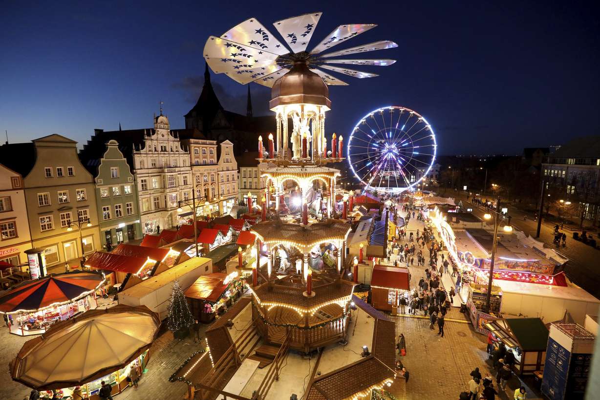 People visit the illuminated Christmas Market in Rostock, Germany, Monday, Nov. 22, 2021.