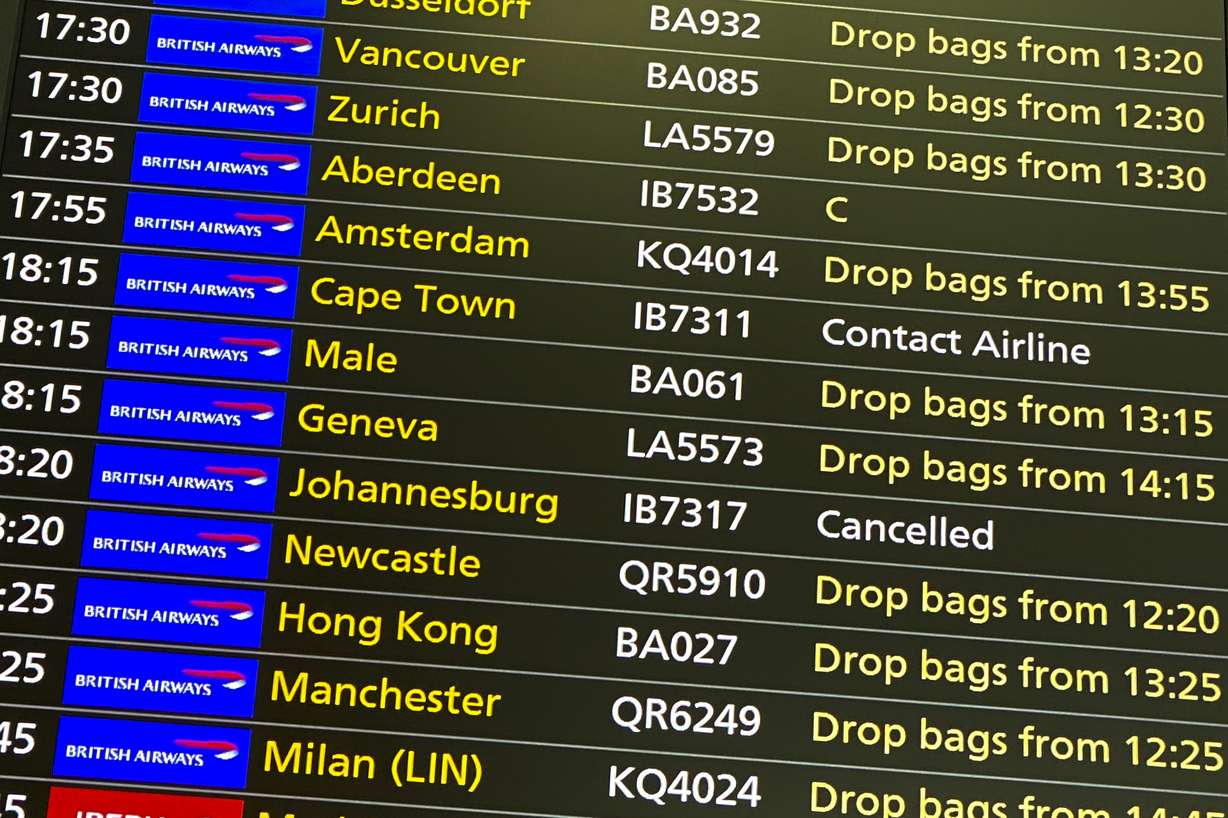 A departures screen displays a cancelled flight to Johannesburg and a message to contact the airline for a scheduled flight to Capetown, at London's Heathrow Airport, Friday, Nov. 26, 2021.