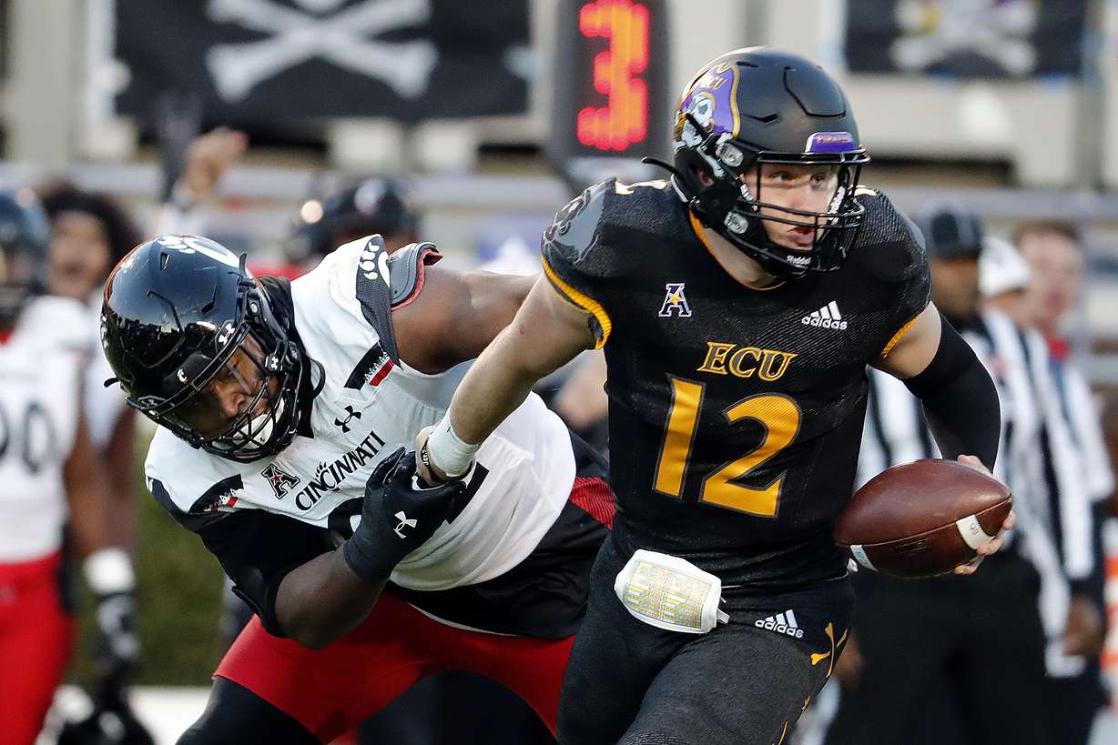Cincinnati's Curtis Brooks (92) grabs the arm of East Carolina quarterback Holton Ahlers (12) for a sack during the first half of an NCAA college football game in Raleigh, N.C., Friday, Nov. 26, 2021.