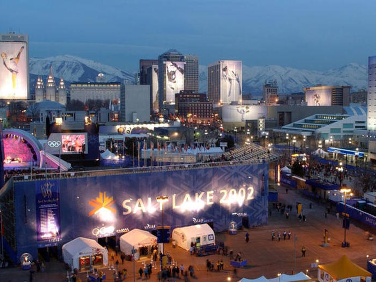 The Salt Lake City skyline is pictured on Feb. 21, 2002, during the 2002 Winter Games. Backers of Utah’s bid to bring the Winter Games back to the state in 2030 or 2034 won’t be traveling to Switzerland to sit down for the first time with International Olympic Committee officials quite as soon as they’d hoped.