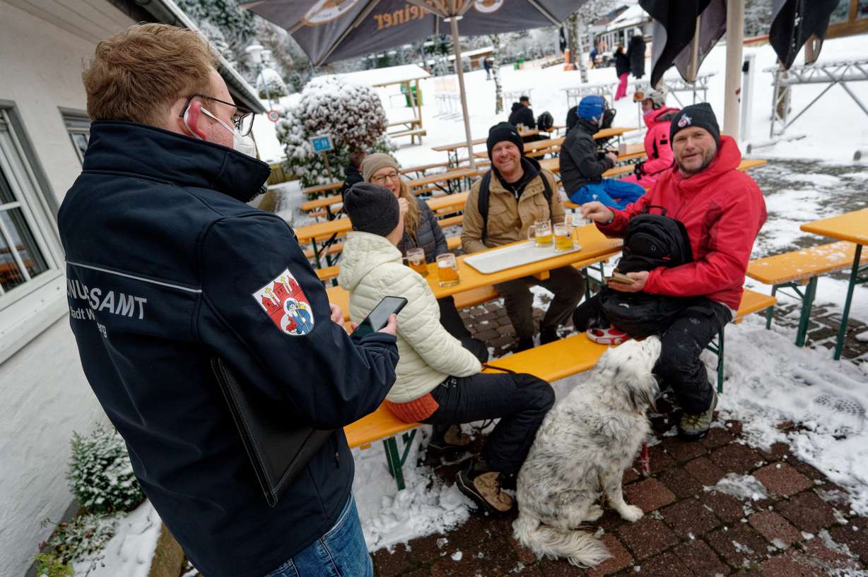 A public order official checks the COVID-19 vaccination certificates of skiers at the Rauher Busch ski slope in Winterberg, Germany, Saturday.