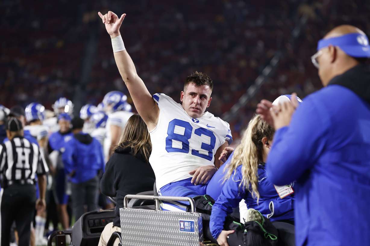 BYU tight end Isaac Rex signals to the crowd after being carted off the field following an injury during the Cougars' regular-season finale at USC, Saturday, Nov. 27, 2021 in Los Angeles.