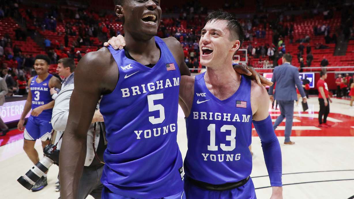 Brigham Young Cougars forward Gideon George (5) and Brigham Young Cougars guard Alex Barcello (13) celebrate the win over Utah in Salt Lake City on Saturday, Nov. 27, 2021. BYU won 75-64.