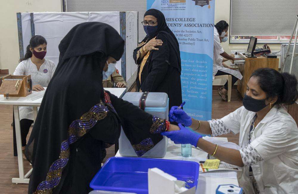 A woman holds her arm after receiving the Covishield COVID-19 vaccine at a vaccination center in Mumbai, India, Monday.