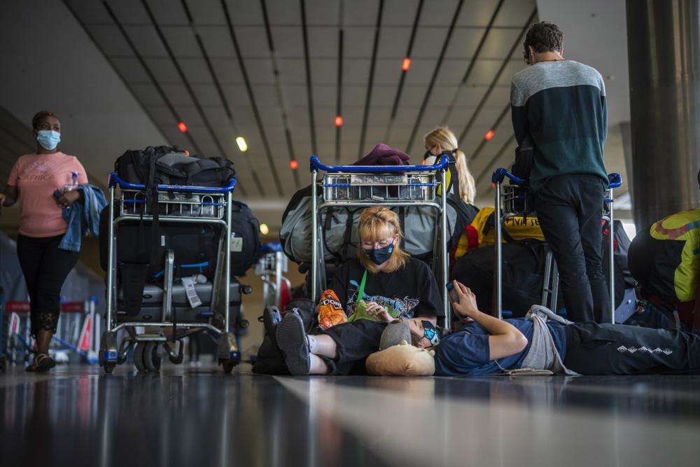 Students from Norway who were on a field trip to South Africa wait to be tested for COVID-19 before boarding a flight to Amsterdam at Johannesburg's O.R. Tambo airport Monday. The World Health Organization urged countries around the world not to impose flight bans on southern African nations due to concern over the new omicron variant.