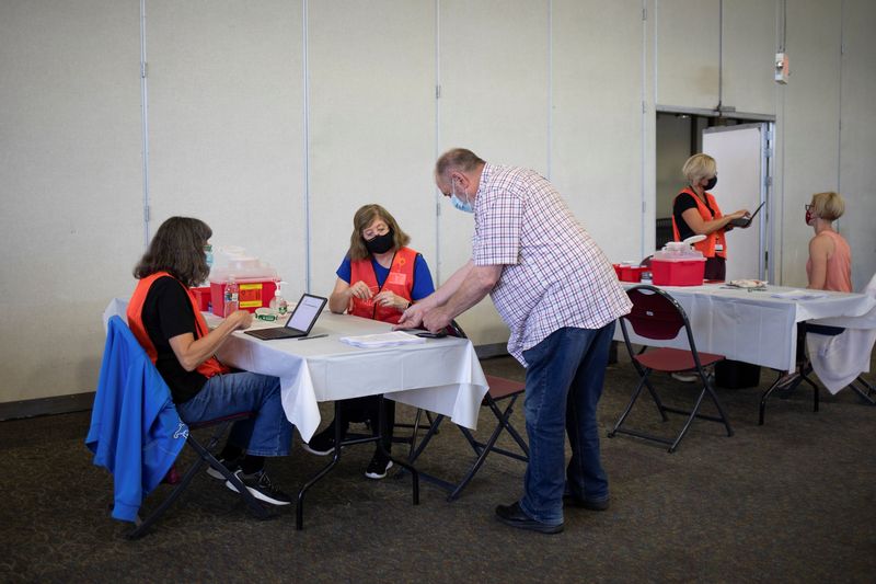 Nurses converse with patients as they check in before they receive their COVID-19 booster vaccination during a Pfizer-BioNTech vaccination clinic in Southfield, Michigan, on Sept. 29.