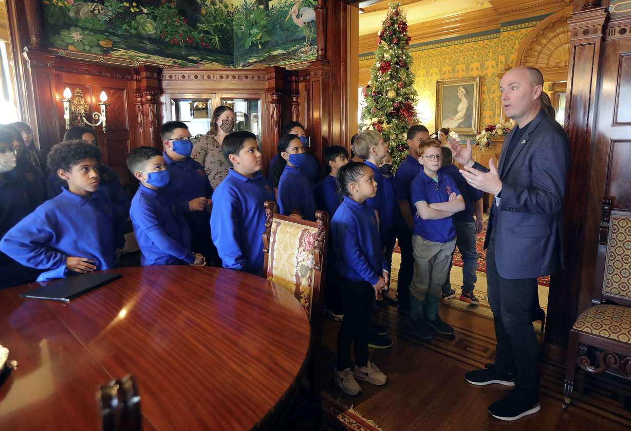 Gov. Spencer Cox, right, gives fourth graders from Wallace Stegner Academy a tour of the Governor’s Mansion, including the dining room, in Salt Lake City on Monday.