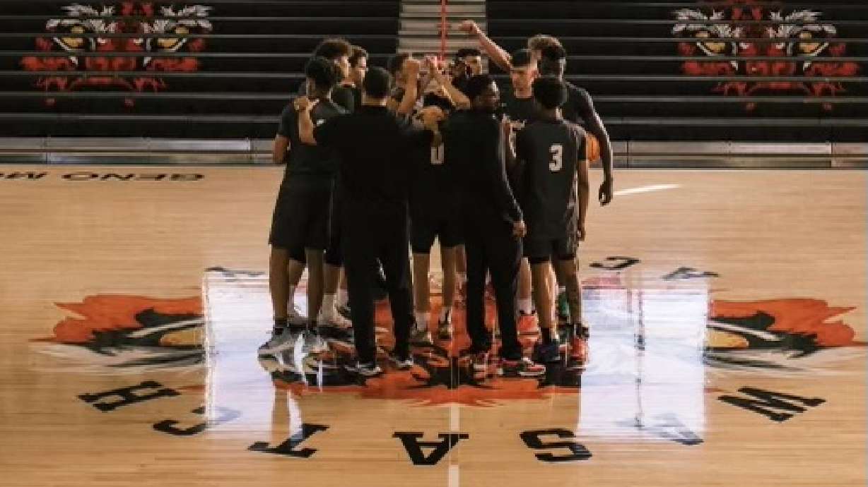 Wasatch Academy players gather in a huddle on the team's basketball court.