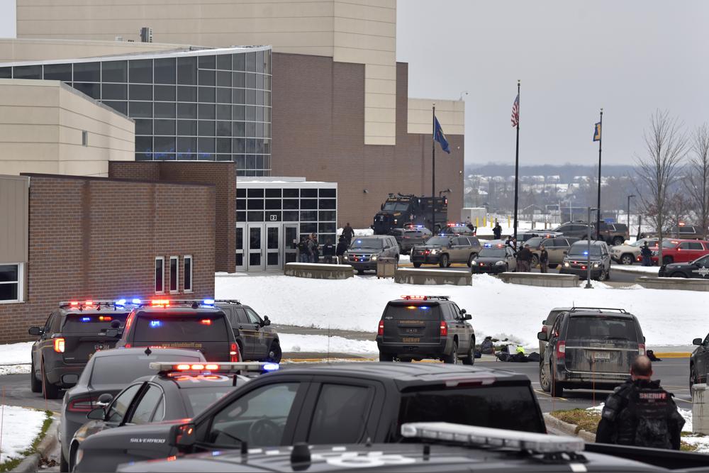 Dozens of police, fire, and EMS personnel work on the scene of a shooting at Oxford High School, Tuesday, in Oxford Township, Mich. 