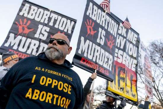 Anti-abortion protesters surround abortion rights advocates as both groups demonstrate in front of the U.S. Supreme Court, Wednesday, in Washington, as the court hears arguments in a case from Mississippi, where a 2018 law would ban abortions after 15 weeks of pregnancy, well before viability.