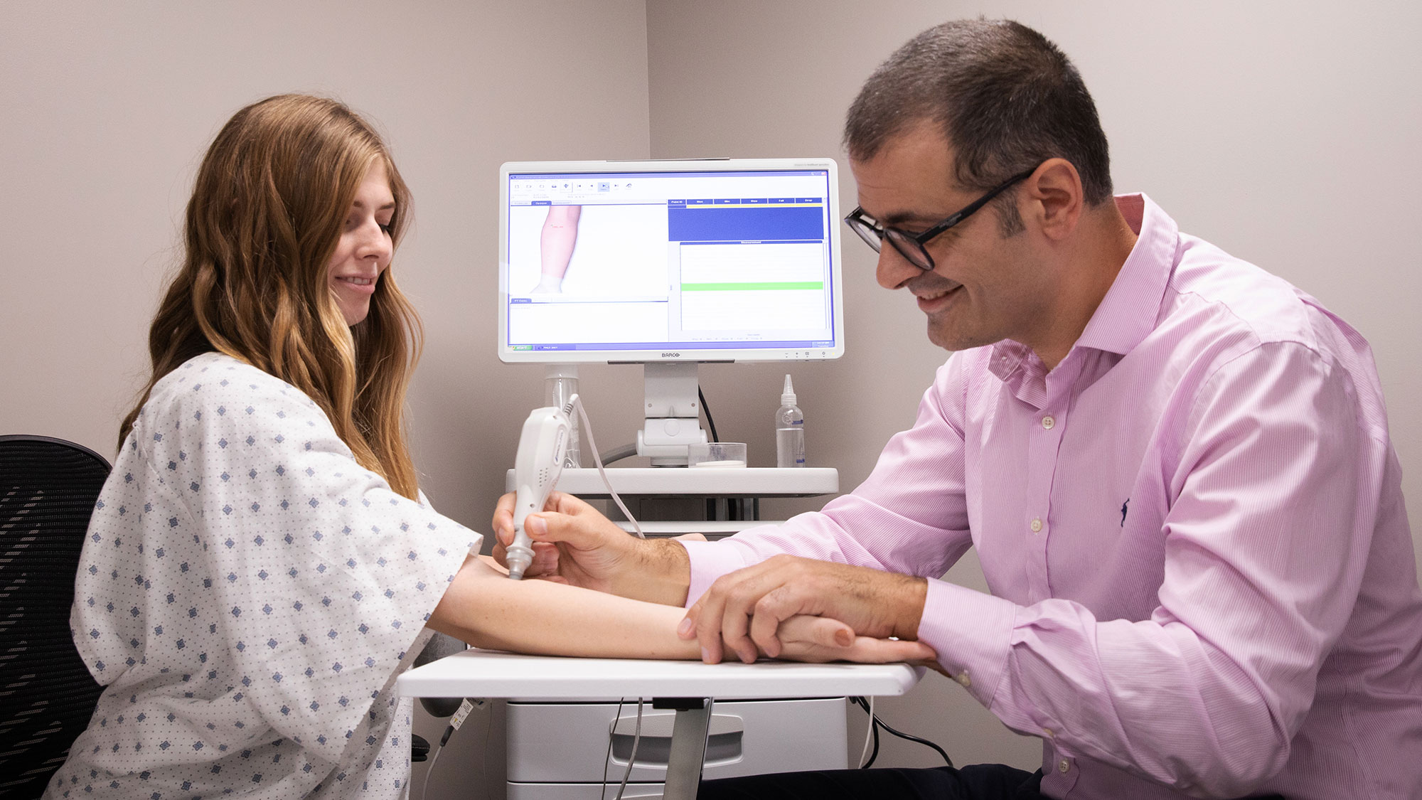 Natasha Andreasen, left, and Benjamin Sanchez-Terrones demonstrate how you would use a new diagnostic tool they are developing to detect breast cancer in a patient.