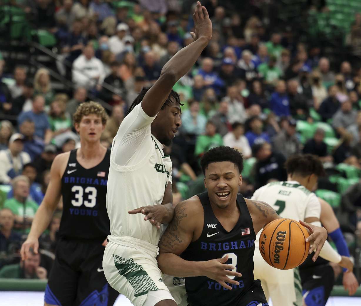 Brigham Young Cougars guard Te'Jon Lucas (3) drives into Utah Valley Wolverines guard Le'Tre Darthard (1) at Utah Valley University in Orem on Wednesday, Dec. 1, 2021.