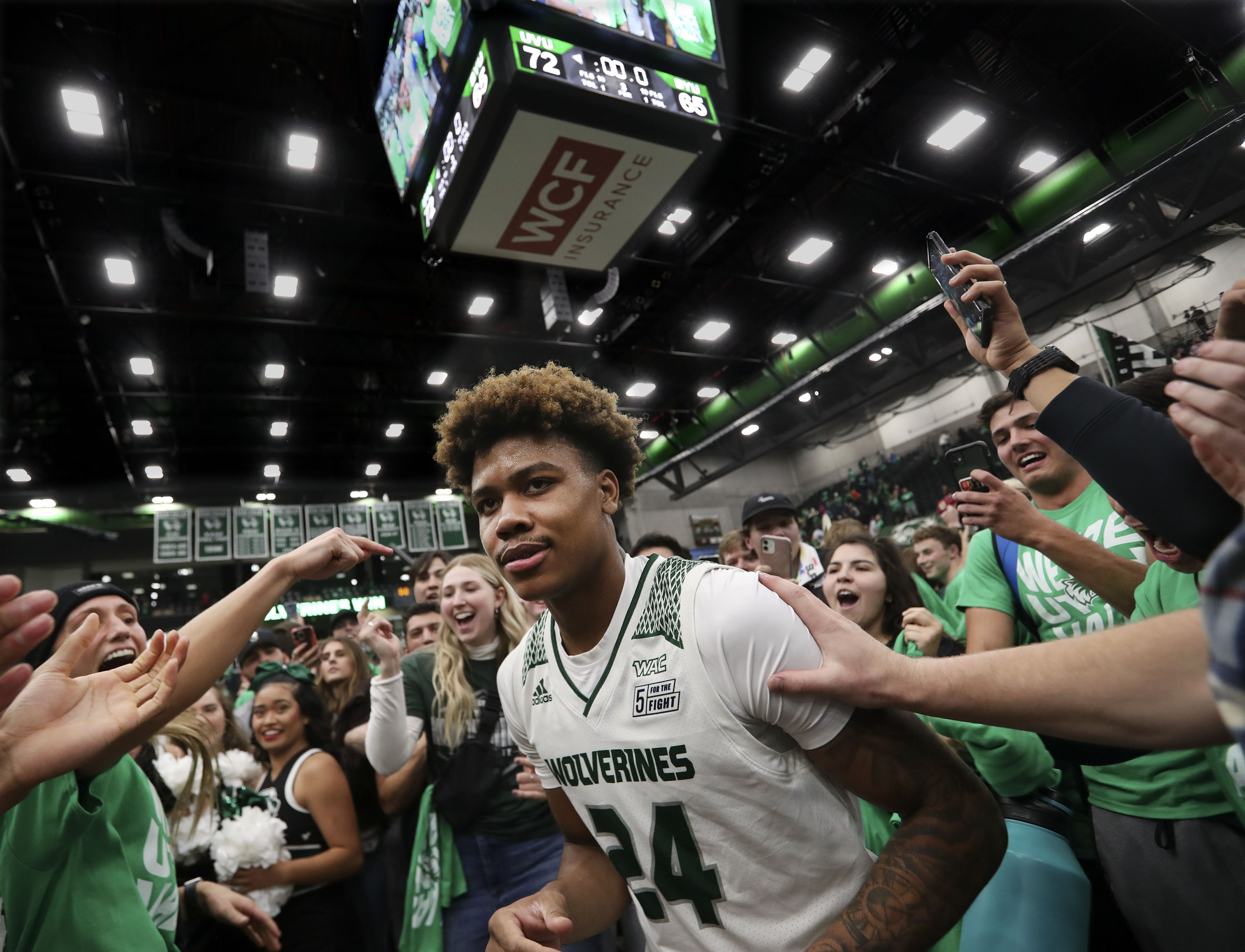 Utah Valley Wolverines guard Justin Harmon (24) is surrounded by fans after the Wolverines beat BYU 72-54 at Utah Valley University in Orem on Wednesday, Dec. 1, 2021.