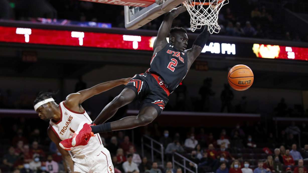 Utah guard Both Gach, right, dunks against Southern California forward Chevez Goodwin during the first half of an NCAA college basketball game in Los Angeles, Wednesday, Dec. 1, 2021.