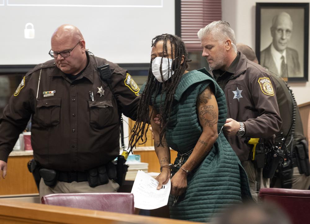 Darrell Brooks, center, is escorted out of the courtroom after making his initial appearance, Tuesday, Nov. 23, in Waukesha County Court in Waukesha, Wis. Prosecutors in Wisconsin have charged Brooks with intentional homicide in the deaths of at least five people who were killed when an SUV was driven into a Christmas parade. 