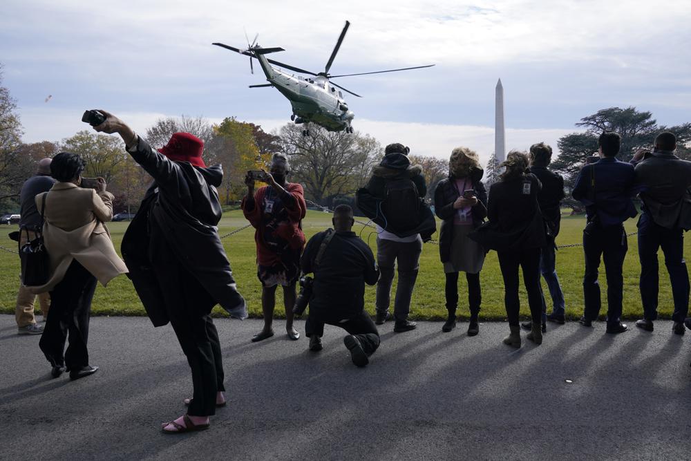 Journalists watch as Marine One, with President Joe Biden on board, lifts off from the South Lawn of the White House in Washington, Thursday, as Biden leaves for a visit to the National Institutes of Health. Biden is expected to unveil an updated strategy to combating the coronavirus.