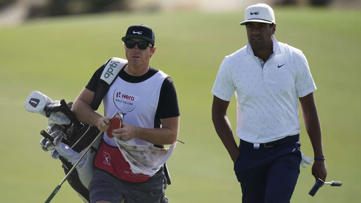 Tony Finau, of the United States, right, and his caddie Ryan Smith, owner of the Utah Jazz and co-founder software firm Qualtrics, enter the third green during the second round of the Hero World Challenge PGA Tour at the Albany Golf Club, in New Providence, Bahamas, Friday, Dec. 3, 2021.