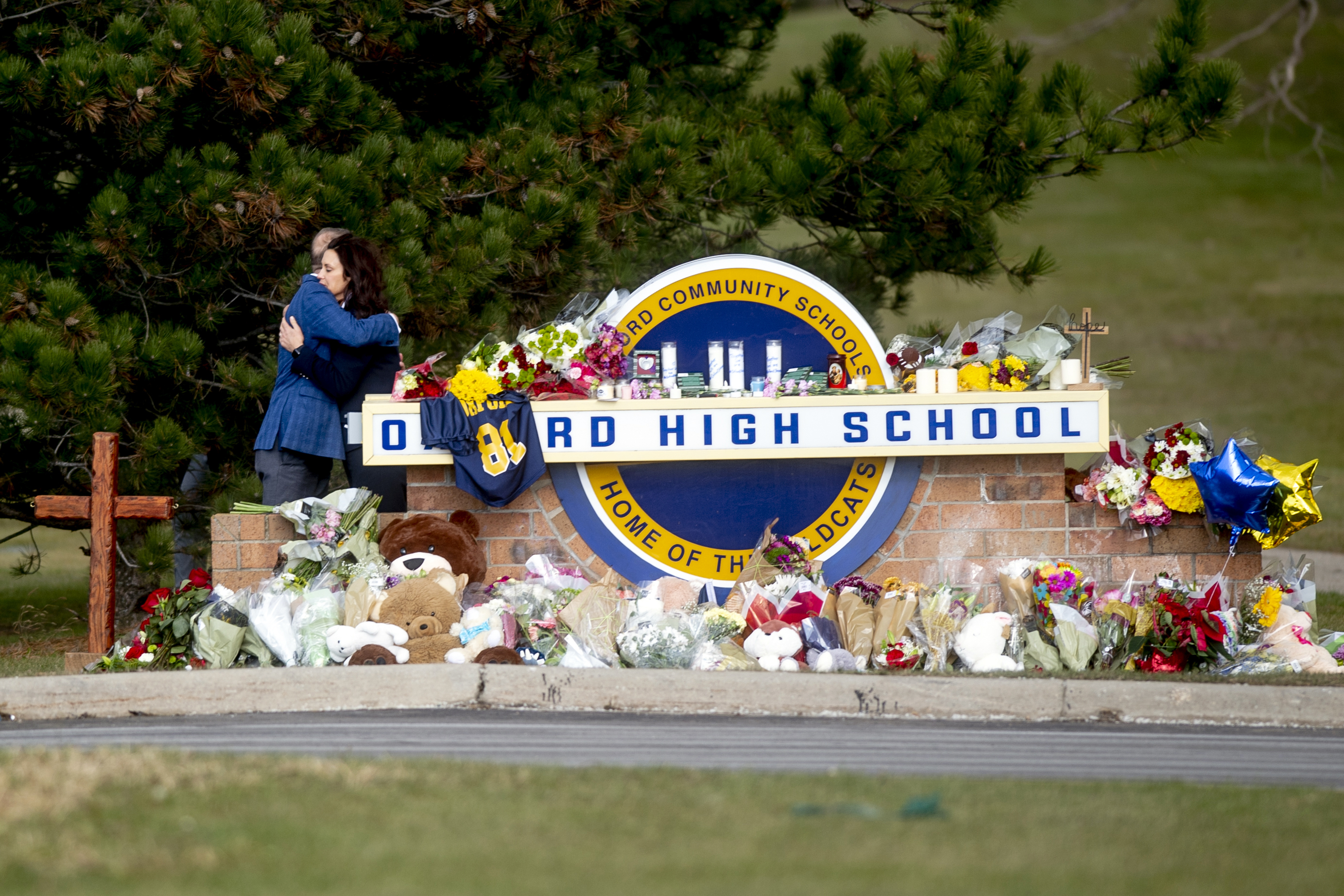 Gov. Gretchen Whitmer embraces Oakland County Executive Dave Coulter as the two leave flowers and pay their respects Thursday morning, Dec. 2, 2021 at Oxford High School in Oxford, Mich.  A 15-year-old boy has been denied bail and moved to jail after being charged in the Michigan school shooting that killed four students and injured others.