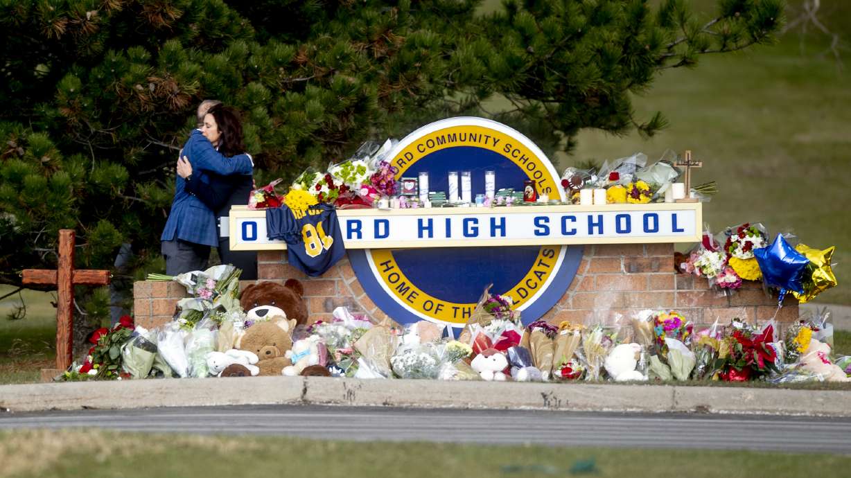 Gov. Gretchen Whitmer embraces Oakland County Executive Dave Coulter as the two leave flowers and pay their respects Thursday morning, Dec. 2, 2021 at Oxford High School in Oxford, Mich. A 15-year-old boy has been denied bail and moved to jail after being charged in the Michigan school shooting that killed four students and injured others.