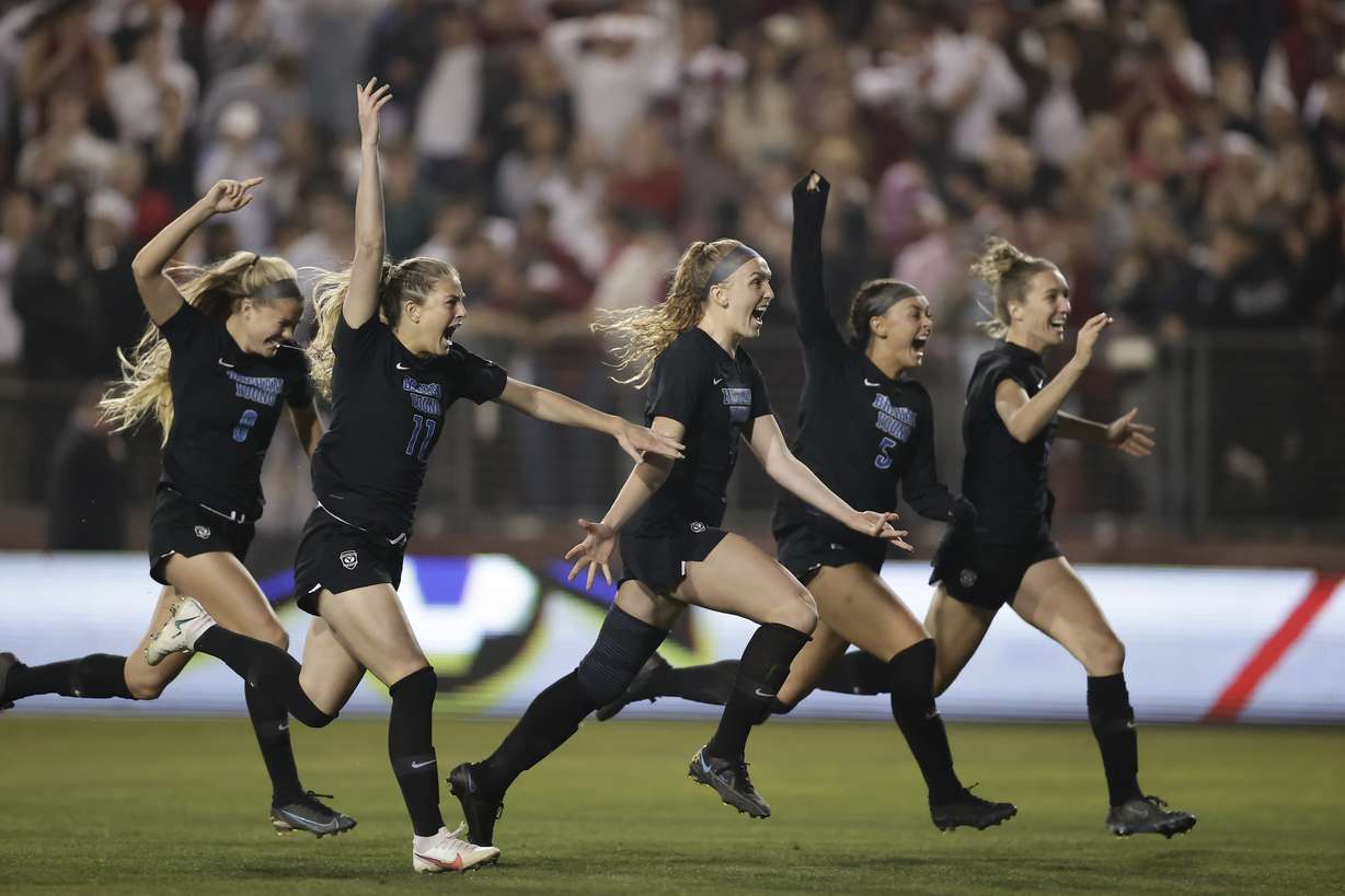 BYU women's soccer players rush goalkeeper Cassidy Smith after the match-deciding penalty kick against Santa Clara during the NCAA College Cup semifinals, Friday, Dec. 3, 2021 in Santa Clara, California.