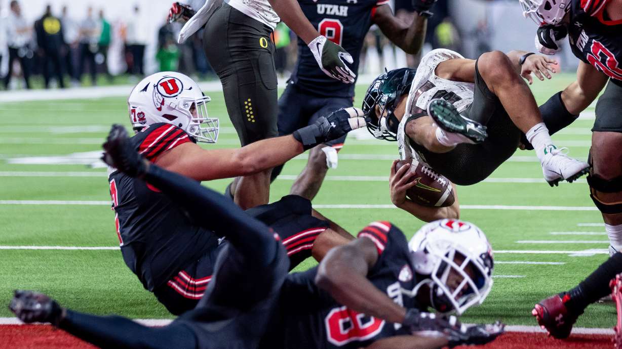 Oregon Ducks running back Travis Dye (26) dives through the Utah Utes defense to get out of the Ducks’ own end zone during the Pac-12 championship game at Allegiant Stadium in Las Vegas on Friday, Dec. 3, 2021.
