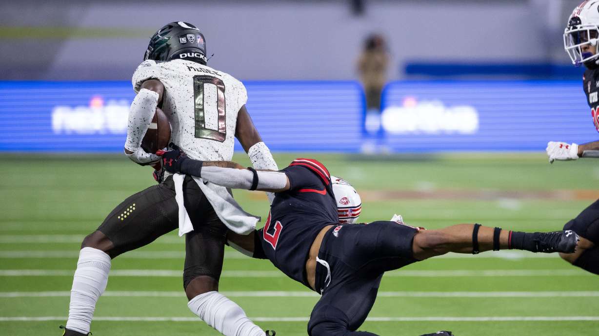 Utah Utes cornerback Kenzel Lawler (2) tackles Oregon Ducks running back Seven McGee (0) during the Pac-12 championship game at Allegiant Stadium in Las Vegas on Friday, Dec. 3, 2021.