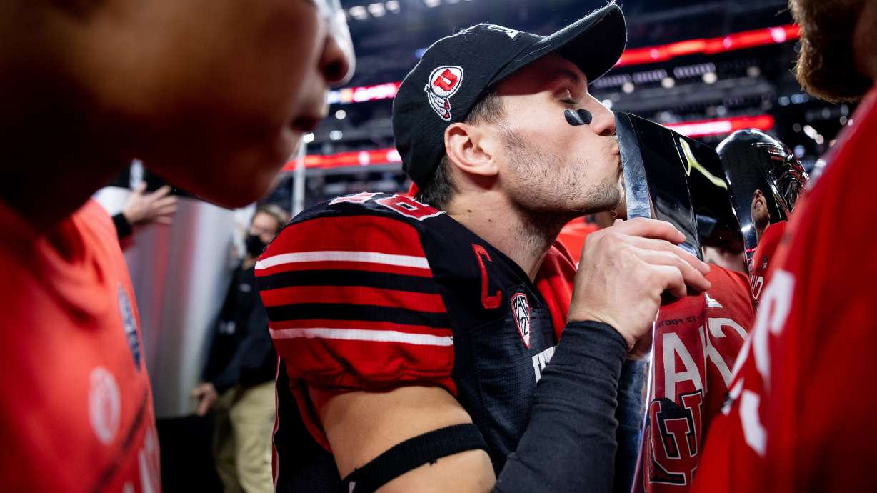Utah Utes wide receiver Britain Covey (18) kisses the trophy after the Utes beat the Oregon Ducks in the Pac-12 championship game at Allegiant Stadium in Las Vegas on Friday, Dec. 3, 2021.