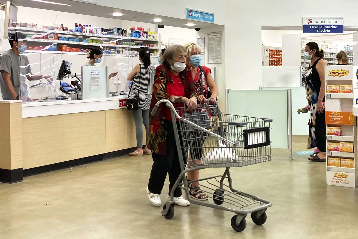 People wear mask as they shop and wait on line at a Walgreens in Wheeling, Ill., on Aug.18.