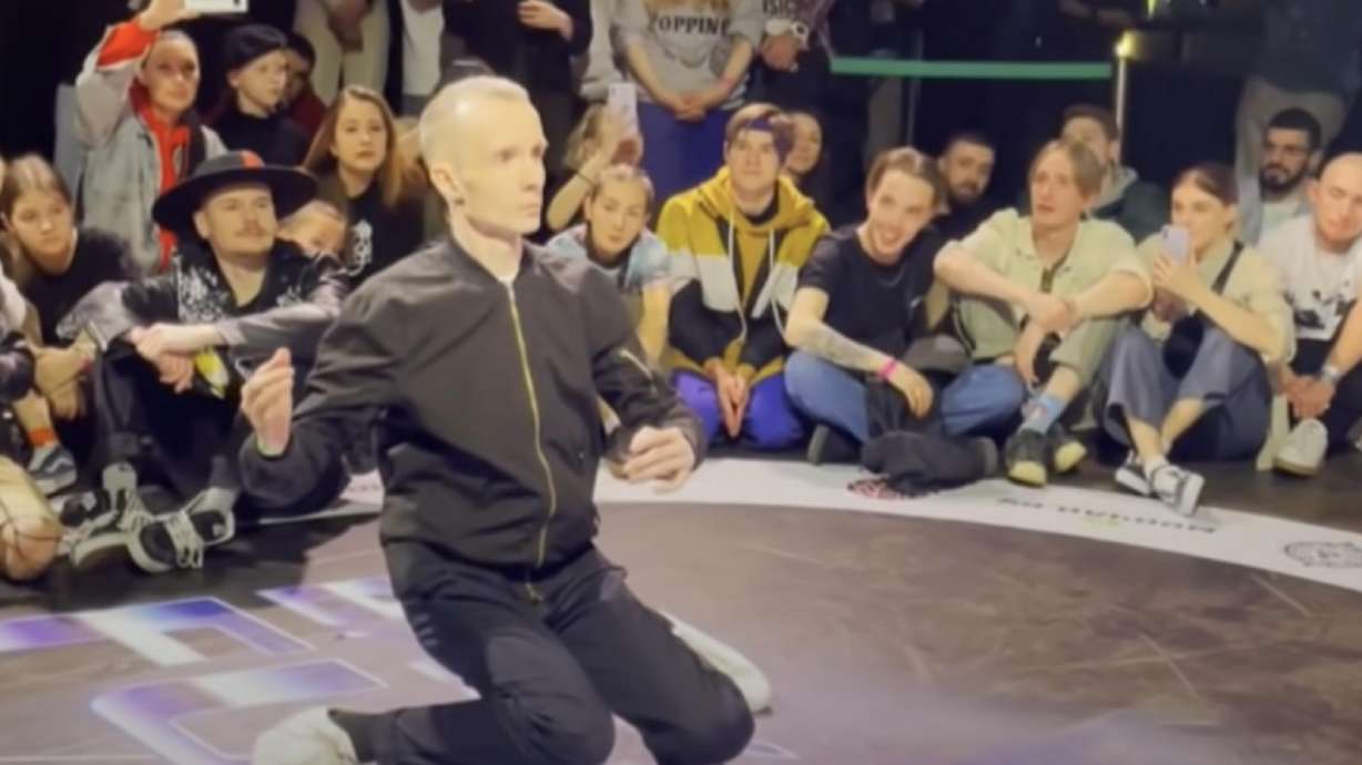 The video shows a classic dance battle setup with two men surrounded by a circle of people while taking turns showing off their best moves.