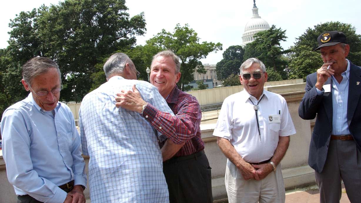 Edward Shames, center, hugs Ed McClung, center left, both members of the World War II Army Company E of the 506th Regiment of the 101st Airborne, with veterans Jack Foley, left, Joe Lesniewski, right, and Shifty Powers, far right, at the Library of Congress in Washington, on July 16, 2003.
