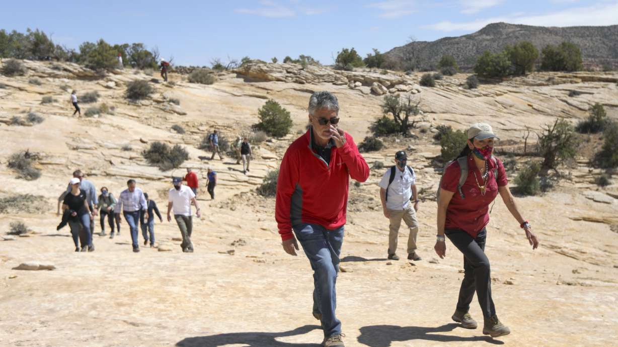 Gary Torres, Bureau of Land Manager district manager for southeast Utah, left, and Department of Interior Secretary Deb Haaland hike to the Butler Wash Ruins in Bears Ears National Monument on April 8. Utah Attorney General Sean Reyes said he selected an outside law firm to aid the state in a possible lawsuit over the Biden Administration's decision to retore the size of the monument.