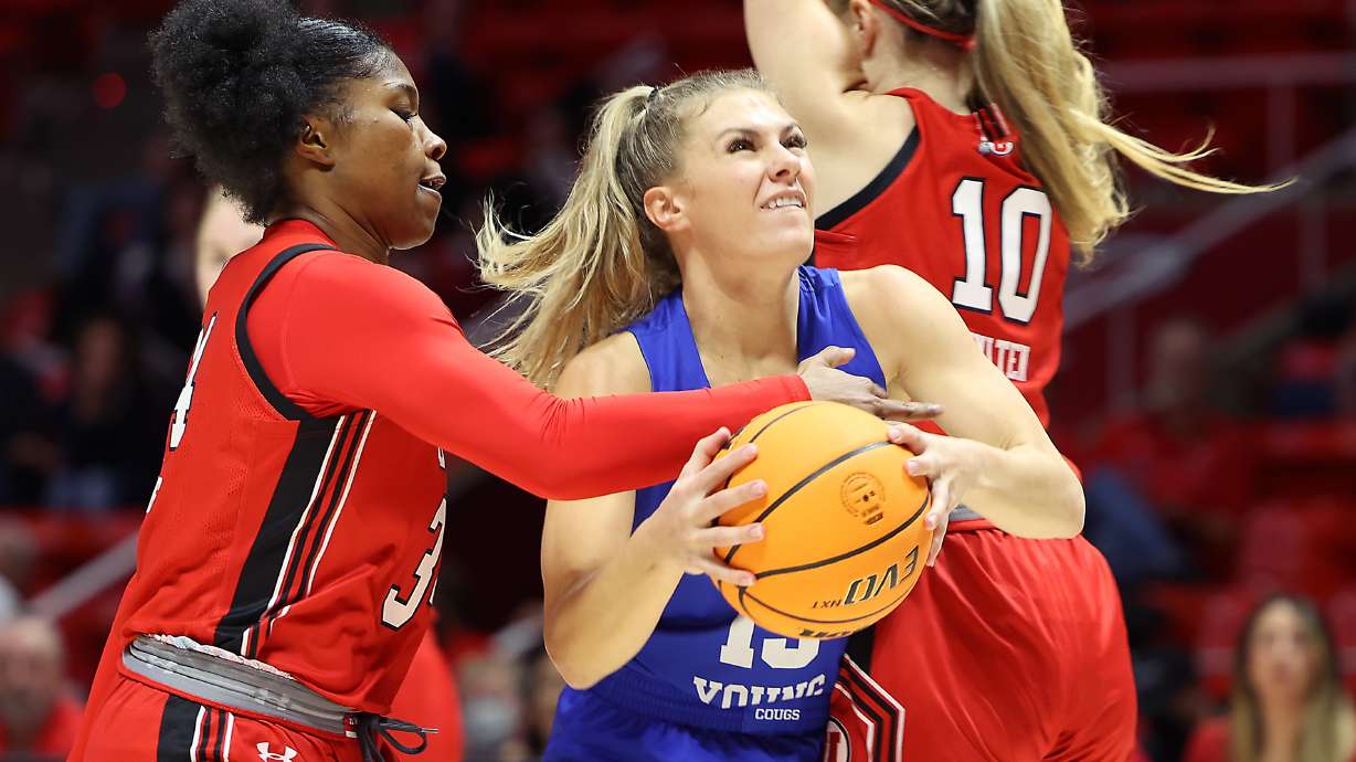 Utah Utes forward Dasia Young (34) fouls BYU Cougars guard Paisley Harding (13) on a drive as Utah and BYU women compete in a basketball game at the Huntsman Center in Salt Lake City on Saturday, Dec. 4, 2021.
