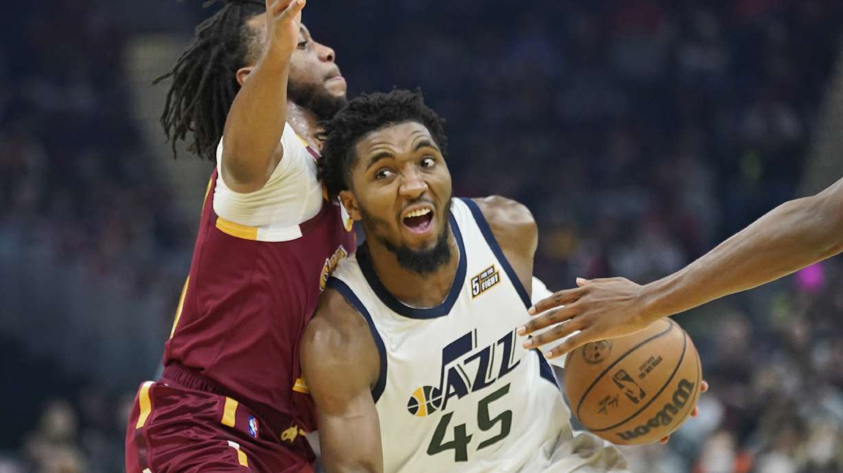 Utah Jazz's Donovan Mitchell (45) drives against Cleveland Cavaliers' Darius Garland, left, in the first half of an NBA basketball game, Sunday, Dec. 5, 2021, in Cleveland. (AP Photo/Tony Dejak)