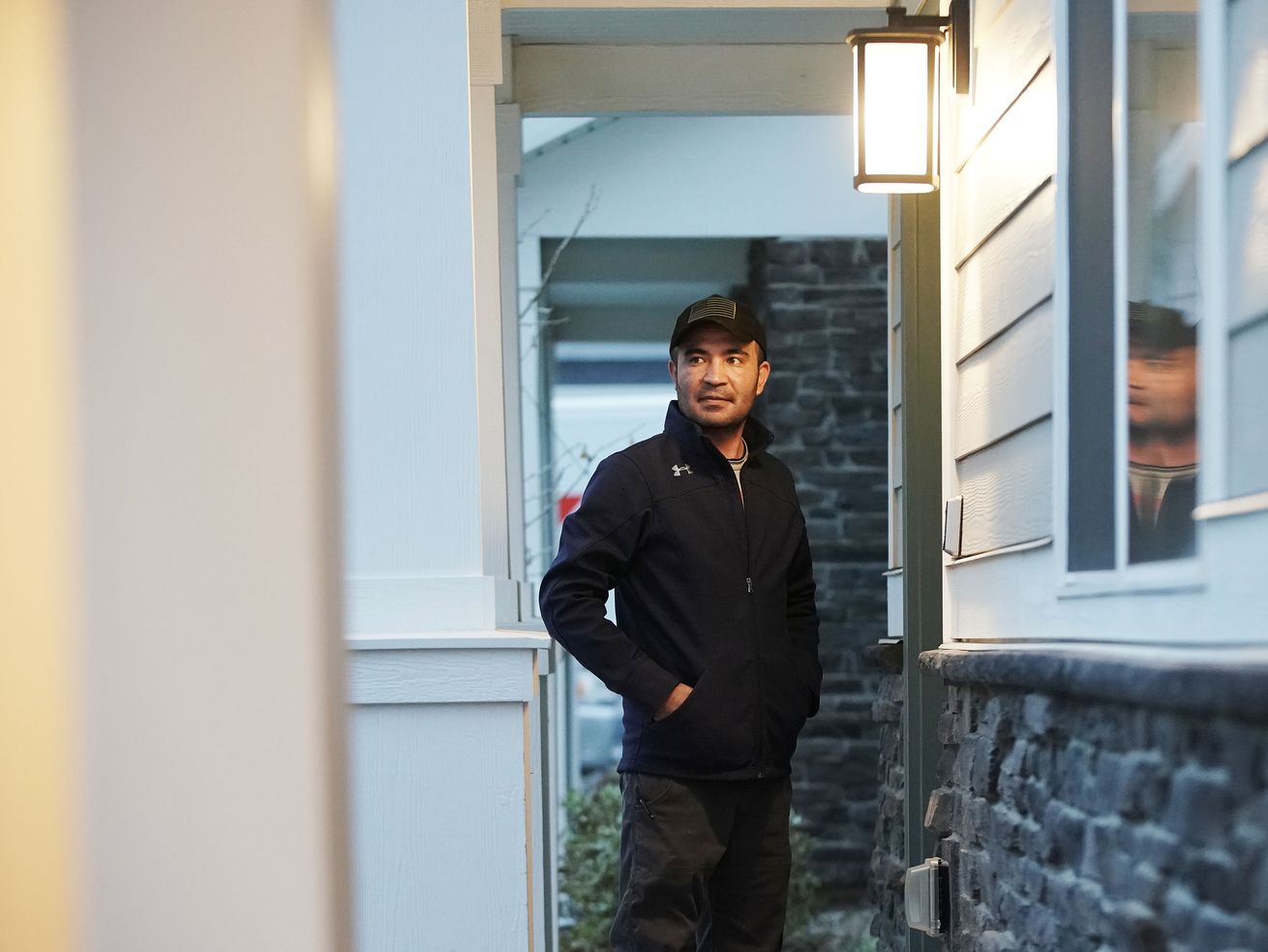 Afghan refugee Abdul, who is only providing his first
name since his family is still in Kabul, stands on his porch at his
home in Herriman on Thursday, Nov. 18.