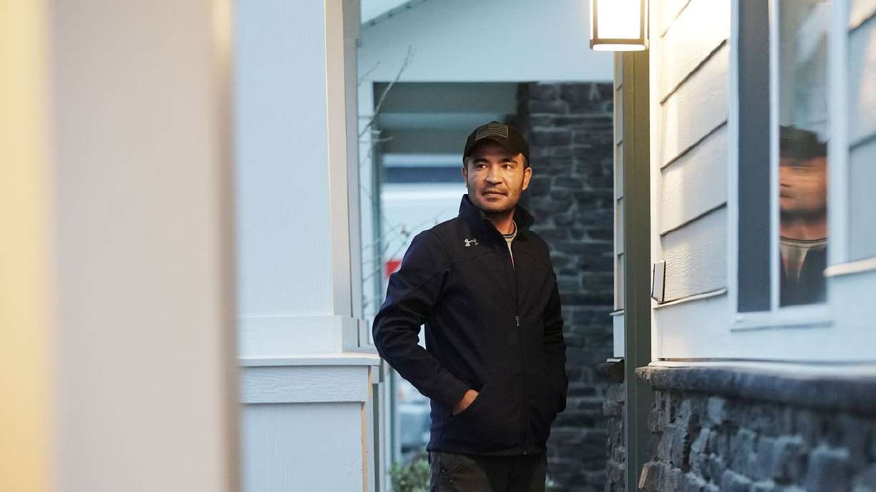 Afghan refugee Abdul, who is only providing his first
name since his family is still in Kabul, stands on his porch at his
home in Herriman on Thursday, Nov. 18.