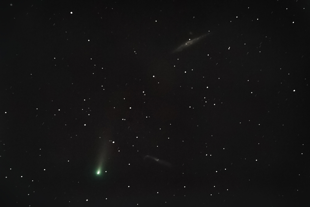 An undated photo of Comet Leonard in the night sky accompanied by two galaxies.