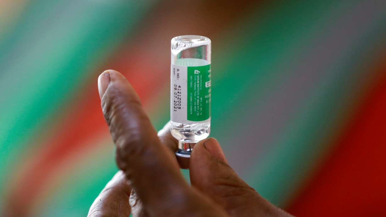 A health care worker holds a vial with the Oxford/AstraZeneca coronavirus disease vaccine at the National hospital in Abuja, Nigeria, March 5.