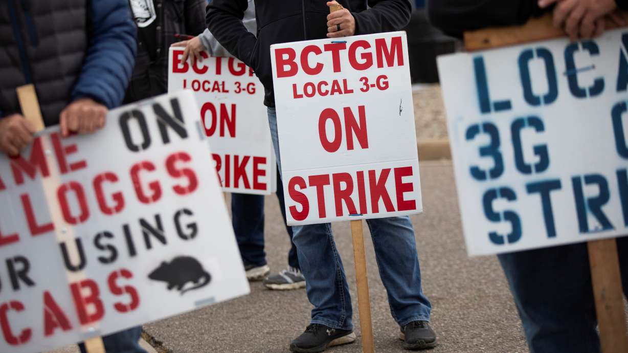 Union workers from Kellogg's gather with signs while they picket outside the cereal maker's headquarters as they remain on strike in Battle Creek, Michigan, Oct. 21.
