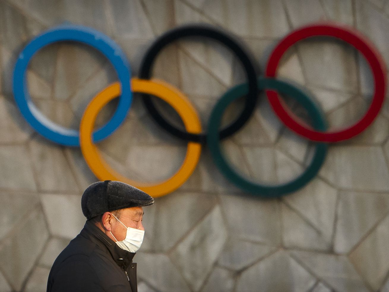 A man walks past the Olympic rings on the National
Stadium, which will be a venue for the 2022 Winter Olympics in
Beijing on Tuesday, Feb. 2, 2021. Nothing will keep Beijing’s 2022
Winter Games from starting as planned next February, International
Olympic Committee officials said Tuesday despite concerns about the
new COVID-19 omicron variant — and a diplomatic boycott by the
United States.