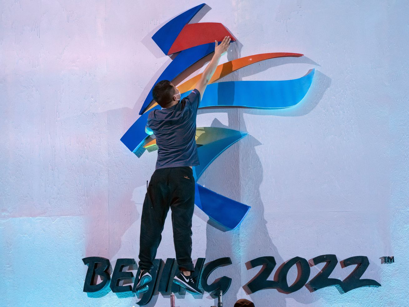 A crew member leaps to fix a logo for the 2022 Beijing
Winter Olympics before a launch ceremony to reveal the motto for
the Winter Olympics and Paralympics in Beijing on Sept. 17.