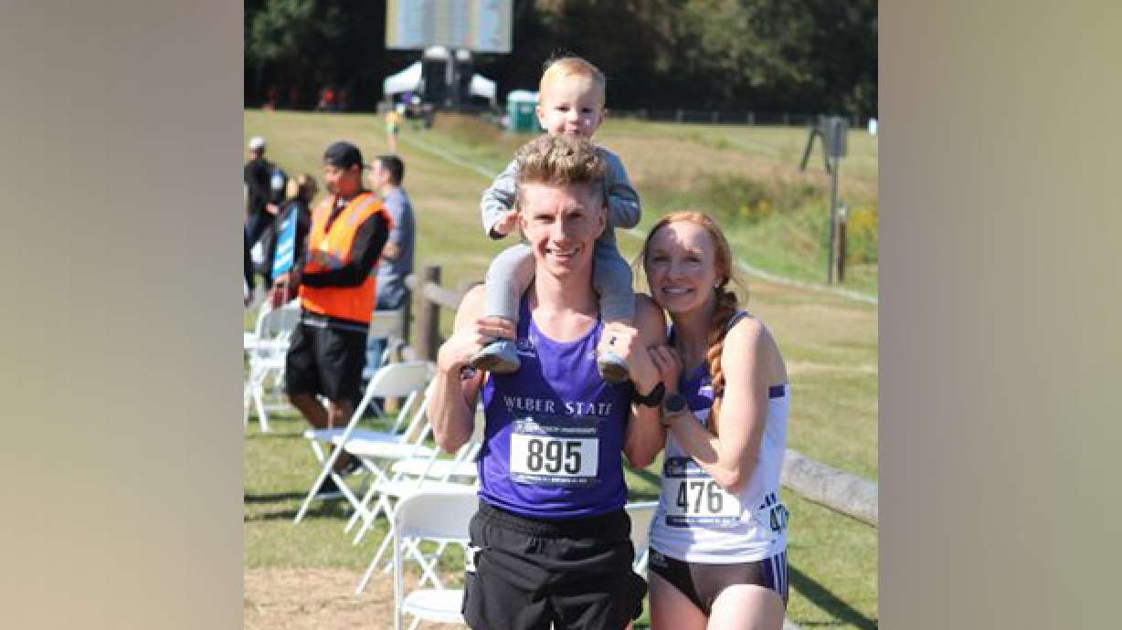 Christian and Summer Allen pose at the NCAA Cross Country National Championships with their son after earning All-American status.