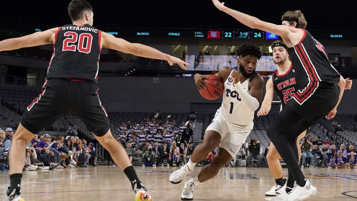 TCU guard Mike Miles (1) drives to the basket as Utah's Lazar Stefanovic (20), Rollie Worster (25) and Branden Carlson, right, defend in the first half of an NCAA college basketball game in Fort Worth, Texas, Wednesday, Dec. 8, 2021.