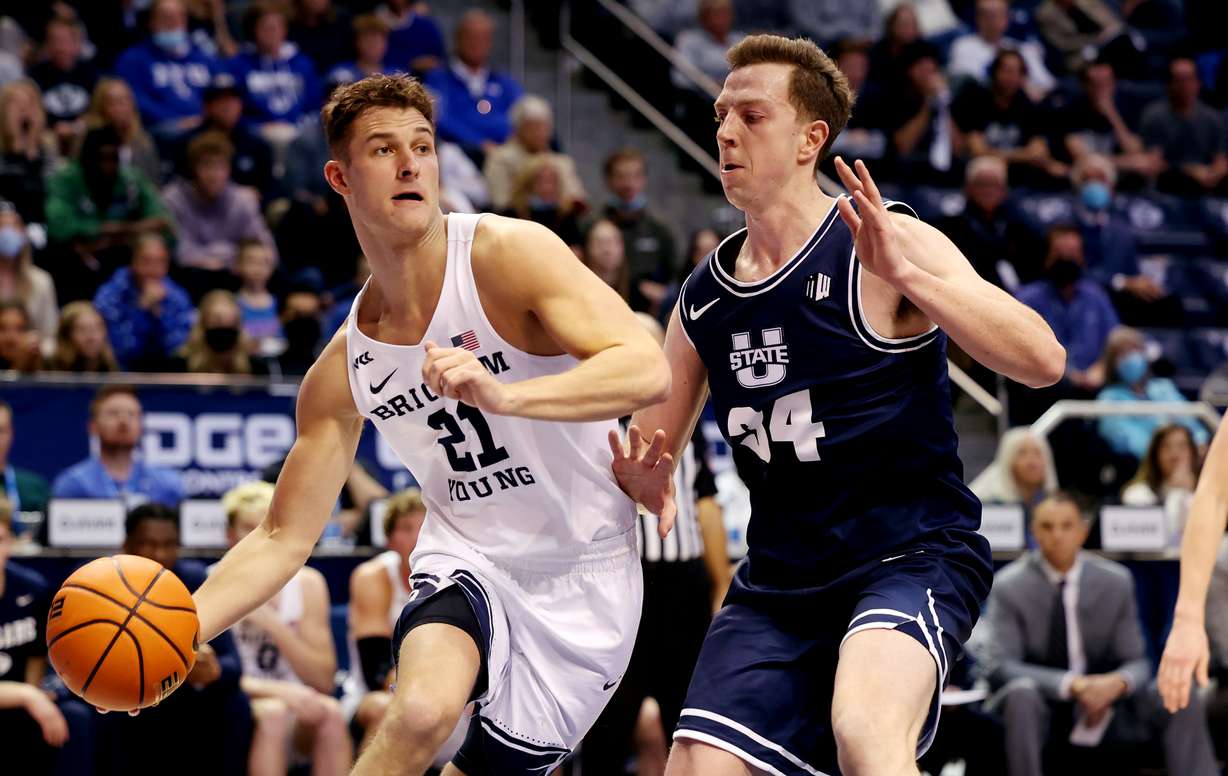 Brigham Young guard Trevin Knell (21) looks to pass the ball with Utah State forward Justin Bean (34) defending as BYU and Utah State play an NCAA basketball game in Provo at the Marriott Center on Wednesday, Dec. 8, 2021. BYU won 82-71.