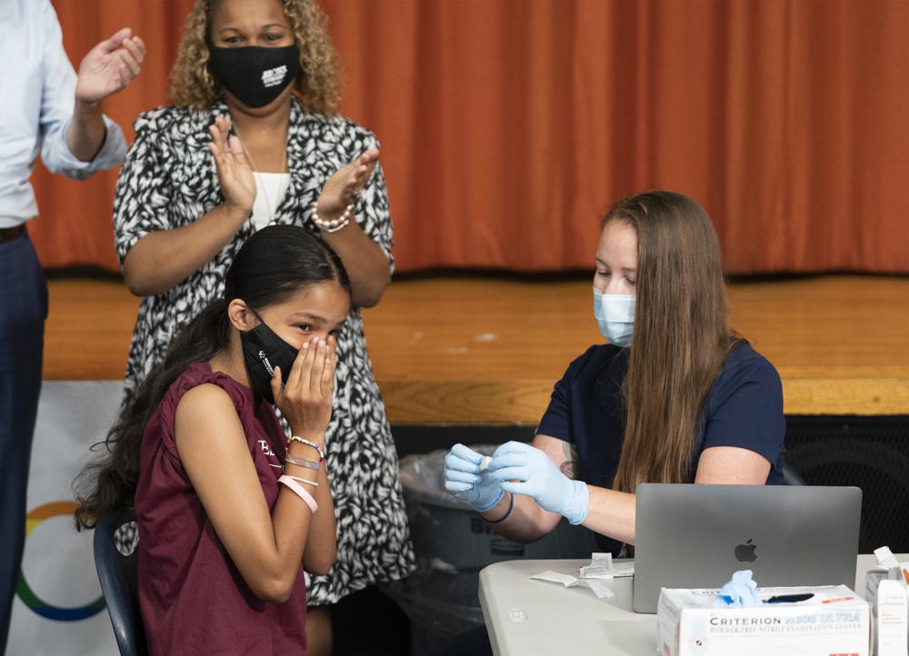 Ariel Quero, 16, left, a student at Lehman High School, reacts after getting the Pfizer COVID-19 vaccine from Katrina Taormina, right, July 27, in New York. US expands Pfizer COVID boosters Thursday, opens extra dose to age 16.