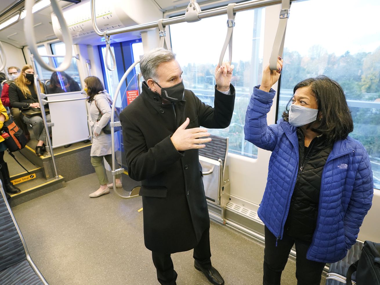 U.S. Rep. Pramila Jayapal, D-Wash., right, leader of the Congressional Progressive Caucus, rides a Link light rail train on Tuesday, Nov. 9, with King County Executive Dow Constantine in Seattle. The caucus has backed Rep. Mark Takano’s, D-California, proposal for a national 32-hour workweek.