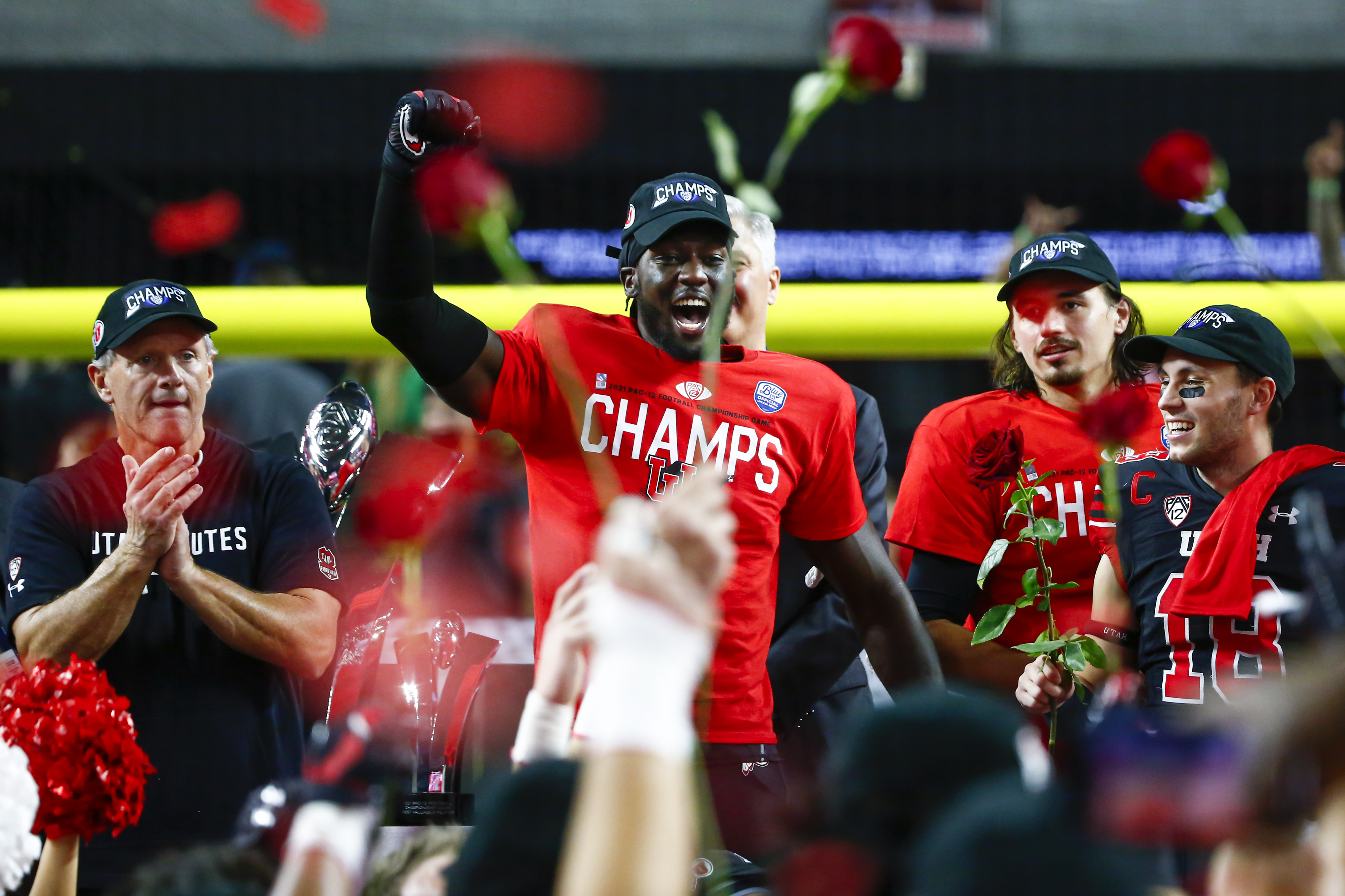 Utah linebacker Devin Lloyd, second from left, celebrates alongside coach Kyle Whittingham, left, quarterback Cameron Rising and wide receiver Britain Covey (18) after Utah defeated Oregon 38-10 to win the Pac-12 Conference championship NCAA college football game Friday, Dec. 3, 2021, in Las Vegas.